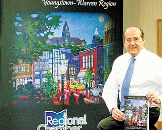 Thomas M. Humphries, President & CEO of the Younstown Warren Regional Chamber, shows a new book promoting the Valley published by the Chamber.