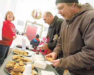 Boardman PTA Council President, Cheryl Dutko, enjoys a laugh as Boardman residents, Ron Mistovich and Dave Erck, grab cookies and hot chocolate during the 14th Annual Boardman Community Christmas at Boardman Township Park on Sunday afternoon..