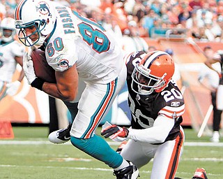 Miami Dolphins tight end Anthony Fasano (80) scores a touchdown as Cleveland Browns cornerback Mike Adams (20) defends in the fourth quarter during an NFL football game in Miami, Sunday, Dec. 5, 2010.