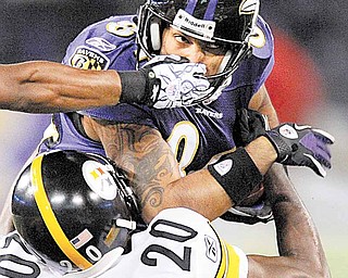 The hand of Pittsburgh Steelers safety Ryan Clark grabs Baltimore Ravens wide receiver T.J. Houshmandzadeh (84) as cornerback Bryant McFadden (20) tackles him during the first half of an NFL football game, Sunday, Dec. 5, 2010, in Baltimore.