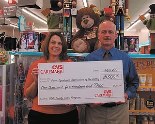 Funds for families: CVS Caremark continued its commitment to helping children with disabilities learn, play and succeed in life by presenting a check for $1,500 to the Down Syndrome Association of the Valley. The check, which will brighten the lives of many, is displayed by, from left, Michele Jones, DSAV co-founder and president, and Carl Sobek, CVS district store manager. DSAV will offer the funds through its family grant program to families of individuals with Down syndrome in the area. DSAV members who wish to enroll their children, under the age of 21, with Down syndrome in inclusive social or recreational opportunities can apply for the funds. The CVS Community Participation Fund and the DSAV funds will provide up to $500 per family per year to help cover the costs related to such activities as Boy/Girl Scouts, Gymboree, ballet, swimming, dance and therapy sessions, which should be open to all children with or without disabilities. For more information visit www.dsav.org or call 330-726-3728.