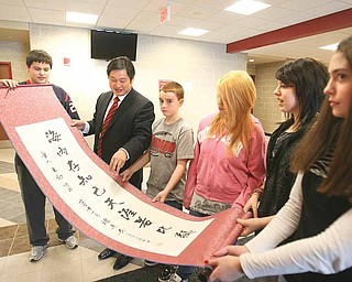 Deng Zhongqing, an educator from China, second from left, shows Girard Junior/Senior High School students a friendship scroll that he brought as a gift. Deng is being hosted by Louise Mason, junior high principal, who will visit China in the spring. Seventh-graders are, from left, Ben Norman, Nick Walker, Destiny Brenna, Alexis Leedy and Lea Buonavola