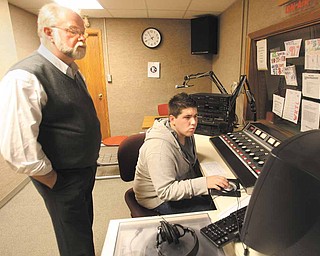 Garrett Hart, a consultant for radio station WAPS in Akron, helps junior Drew Pearson in the WKTL booth next to Tom Krestel’s Broadcast Arts classroom at Struthers High School.