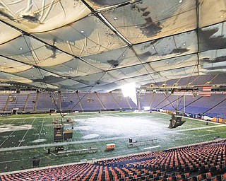Snow falls into the field from a hole in the collapsed roof of the Metrodome in Minneapolis Sunday, Dec. 12, 2010. The inflatable roof of the Metrodome collapsed Sunday after a snowstorm that dumped 17 inches (43 cms) on Minneapolis. No one was hurt, but the roof failure sent the NFL scrambling to find a new venue for the Vikings' game against the New York Giants.
