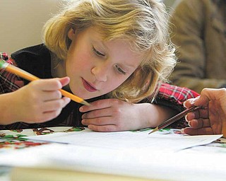 Natalia Novicky, 8, practices use of present tense verbs as part of weekly tutoring. The third-grader is orginally from Ukraine and still learning English at Watson Elementary School.