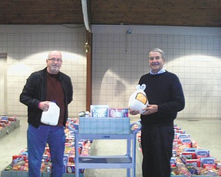 Meals to be thankful for: Kiwanis Club of Western Mahoning County provided 100 Thanksgiving baskets for the less fortunate in the Mahoning Valley during the recent holiday. The turkeys and all the trimmings, fruit, desserts and breakfast items were purchased and assembled at the Henry Nemenz IGA on Meridian Road. Looking over some of the items before they were distributed by Kiwanis members or taken to the Saxon Club to be picked up by recipients are, from left, Kiwanians Tom Eisenbraun, lieutenant governor of Division 21, and Steve Marshall, interclub chairman. Funds to support the annual project were contributed by the Kiwanis clubs of Youngstown and Western Mahoning County and included a $1,000 grant from the District Kiwanis Foundation.