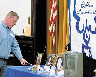Lighting of a candle in honor of military personnel during a candle light vigil organized by the Bereaved Parents of the USA's Mahoning County Youngstown Chapter at the First Presbyterian Church Tuesday evening.