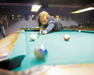 Earl Strickland, former world-champion pool player, practices at the Ice Breakers pool hall behind the Ice House Inn in Austintown. Strickland, of Greenboro, N.C., was introduced to the bar’s owner about 18 months ago and stops by to give lessons or exhibitions.