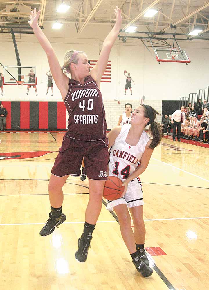 BASKETBALL - (14) Allie Pavlansky of Canfield drives to the hoop as (40) Kayleigh Lipke of Boardman plays defense during their game Wednesday night.