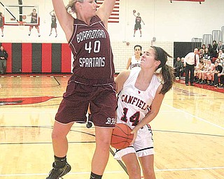 BASKETBALL - (14) Allie Pavlansky of Canfield drives to the hoop as (40) Kayleigh Lipke of Boardman plays defense during their game Wednesday night.