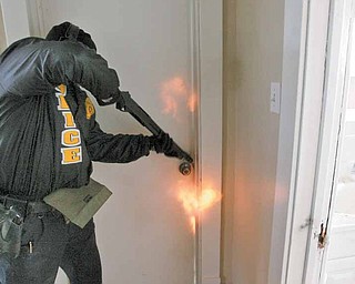 A shotgun blast blows the latch off a bedroom door as part of a tactical-entry training exercise by members of the Mahoning Valley Violent Crimes Task Force.