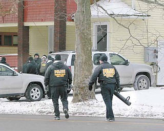 Law-enforcement officials approach a vacant house on Southern Boulevard they used as a training location and to show police presence in the neighborhood on Youngstown’s South Side.