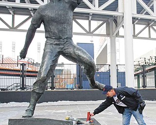 Joe Skerk, 47, places an "A" with the number 19 written on it, at the Bob Feller statue at Progressive Field Thursday, Dec. 16, 2010, in Cleveland. The "A" recognizes the service on the warship "Alabama" by Feller. Feller, one of baseball's greatest pitchers during a Hall of Fame career with the Cleveland Indians, died Wednesday night Dec. 15, 2010. He was 92.
