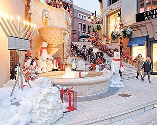 Shoppers walk into the Two Rodeo Drive shopping district decorated for the Holidays in Bevery Hills, Calif. on Wednesday, Dec. 15, 2010.
