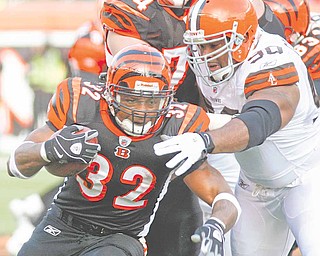 Cincinnati Bengals running back Cedric Benson (32) is tackled by Cleveland Browns defensive end Kenyon Coleman (90) in the first half of an NFL football game, Sunday, Dec. 19, 2010, in Cincinnati.