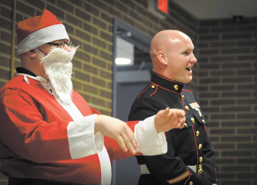 Steve Gasior, an eighth-grade science teacher, donned at Santa suit Monday as part of the Toys for Tots talent show at Choffin Career and Technical Center. Sgt. Robert Eggleston of the Marines took in the show with Santa. The talent show was a fundraiser for Toys for Tots and raised $900 for the cause.