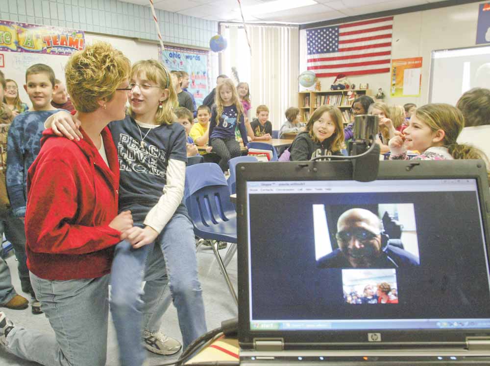 Geoff Clark, a U.S. Air Force Reservist speaks, to his daughter Kayla Clark and wife Kim Clark, at left, Monday using Skype, a program that allows users to chat online through video. Clark also answered questions from fourth-graders at Jackson-Milton Elementary during his digital visit. 