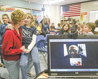 Geoff Clark, a U.S. Air Force Reservist speaks, to his daughter Kayla Clark and wife Kim Clark, at left, Monday using Skype, a program that allows users to chat online through video. Clark also answered questions from fourth-graders at Jackson-Milton Elementary during his digital visit. 