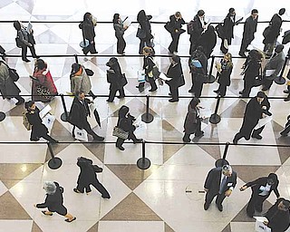 FILE - In this March 20, 2009 file photo, a line of job applicants snakes through a ropeline to attend the CUNY Big Apple Job Fair, in New York.