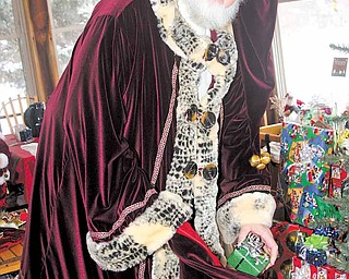 Santa representative Howard Huffman loads gifts into his bag at his home in Hubbard. Huffman had his suit specially made to fill the role of one of Santa’s official helpers.