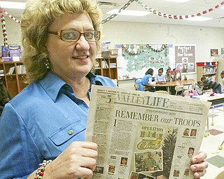Taft Elementary fourth-grade teacher Laurie McEwan holds the Nov. 7 edition of The Vindicator with the “Operation Holiday Cheer” feature that prompted the idea.