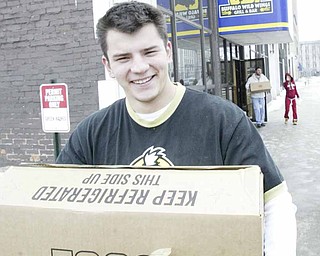 Brad Yaskowitz, an employee of Buffalo Wild Wings restaurant in downtown Youngstown, hauls eggs donated by his employer and Save-A-Lot stores to needy families. The restaurant here and in Niles passed out food Wednesday in Mahoning and Trumbull counties.