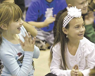 Second graders Teegan Graff, left, and Brianna DiFabio watch as the Poland High School show choir performs at Union Elementary Wednesday.