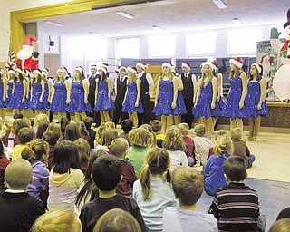 Poland Union Elementary School students watch as the Poland High School show choir performs a variety of seasonal songs.