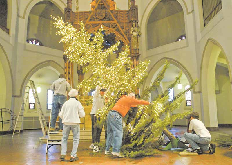 Volunteers at  the Youngstown church work on steadying the blue spruce that will decorate the sanctuary for Christmas. The tree will be arrayed with some 9,600 white lights. It had been targeted for uprooting in the city’s Operation Redemption program to clean up the South Side neighborhood near St. Dominic Church.
