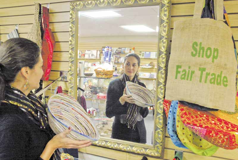 Yasmin Flor, manager of the Villa Shoppe in Villa Maria Community Center, holds a bowl made in Vietnam. The shop sells Fair Trade handcrafted items from Peru, Haiti, Bolivia, Mexico, El Salvador, Bangladesh, Philippines, India, Guatemala and Africa, as well as the United States.