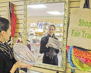 Yasmin Flor, manager of the Villa Shoppe in Villa Maria Community Center, holds a bowl made in Vietnam. The shop sells Fair Trade handcrafted items from Peru, Haiti, Bolivia, Mexico, El Salvador, Bangladesh, Philippines, India, Guatemala and Africa, as well as the United States.