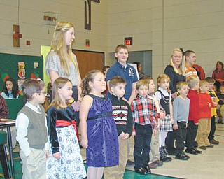 A lighthearted holiday song: Backed up by students from the eighth-grade class at St. Patrick School in Hubbard, who provided their own version of the holiday classics, this group of kindergarten students entertained family and friends on Dec. 16 with their lively rendition of the holiday song “Rudolph the Red Nosed Reindeer.” The song was one of those featured as students from various classes took part in an annual program, “A Christmas Spelling Bee,” written and directed by Mrs. Joan Deramo, music teacher, who was presented with a Christmas arrangement in recognition of her hard work. 