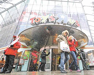 Shoppers leave the Toys R Us store in New York's Times Square, Sunday, Dec. 26, 2010.