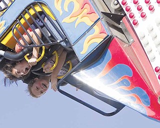 Carlie Chepke, 15, and Sarah Melfe, 14, both of Austintown, scream as they find themselves inverted on a fair ride that takes riders around in a loop on Sunday afternoon.