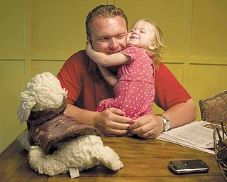YSU Head Football Coach Eric Wolford, shares a moment with his daughter Marlee at the Wolford Home in Liberty on Thursday afternoon.