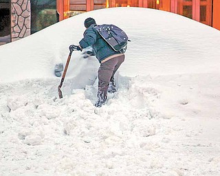 John Elliot of New York tries to dig out his rental car on a Manhattan street Monday, Dec. 27, 2010, thanks in part to a good samaritan who let him use a shovel, in the wake of a major snow storm that hammered New York and much of the Northeast.