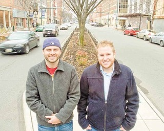 Cars pass by as Be My Designated Driver co-founders Mac Chrystal and Brian DiBacco stand outside of the Lemon Grove on Friday afternoon.