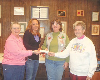 The spirit of giving: Sister Midge, Lisa Petro, Roberta Lawrentz of Girard Junior Women, and Sister Marjorie, from left to right, display a check that was presented to the Emmanuel Care Center in Girard. The check is from Girard Junior Women, who sponsor fundraisers that benefit the Girard community. GJW donates annually to the Emmanuel Care Center, which provides for the needy families of Girard. For Thanksgiving the group donated 400 bags of food and IGA gift certificates, and for Christmas they donated 600 presents. The center houses transitional families.