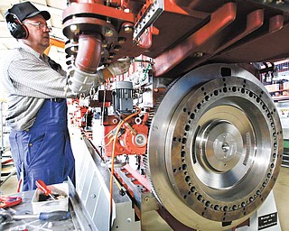 n ths Feb. 17,2009 file photo, an engine technician works on a vessel engine at the Caterpillar company in Friedrichsort near Kiel, northern Germany. More than half of the 15,000 people that Caterpillar Inc., maker of the signature yellow bulldozers and tractors, has hired this year were outside the U.S.