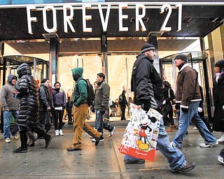 In this Dec. 26, 2010 file photo, people walk past a Forever 21 store in New York's Times Square. A new survey shows consumer confidence dipped in December, even after other reports suggest people increased their holiday spending at the biggest rate in four years.