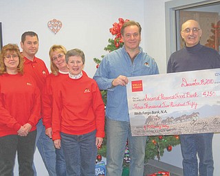 Making an investment: Wells Fargo Advisors made a sizeable investment in the community recently by providing a $4,250 grant to Second Harvest Food Bank of Mahoning Valley. The grant will help the food bank provide food for those in need in the Mahoning Valley. Wells Fargo & Co. has a strong legacy of giving to the community. In 2009 the combined company contributed more than $200 million in grants and sponsorships to nonprofit organizations and 1.4 million team-member hours volunteering in communities across the United States. Participating in the presentation of the grant to Second Harvest were, from left, Patti Wilson, David Patrick, Sandy Haynes and Beth Ortz, who watched as David Croutch, manager of the Canfield Branch of Wells Fargo Advisors, passed a facsimile of the check to Michael Iberis, executive director of the food bank.