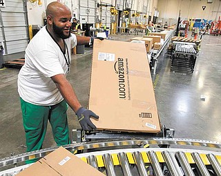 In this Nov. 11, 2010 photo, Leacroft Green places a package to the correct shipping area at an Amazon.com fulfillment center, in Goodyear, Ariz. Amazon.com, the source of many presents good, bad or ugly, has patented a system that would let people exchange unwanted gifts for those they want before anything is actually shipped. For now, though, it's just a patent, so until Amazon figures out how to implement it, you may be stuck with that itchy sweater from grandma. 