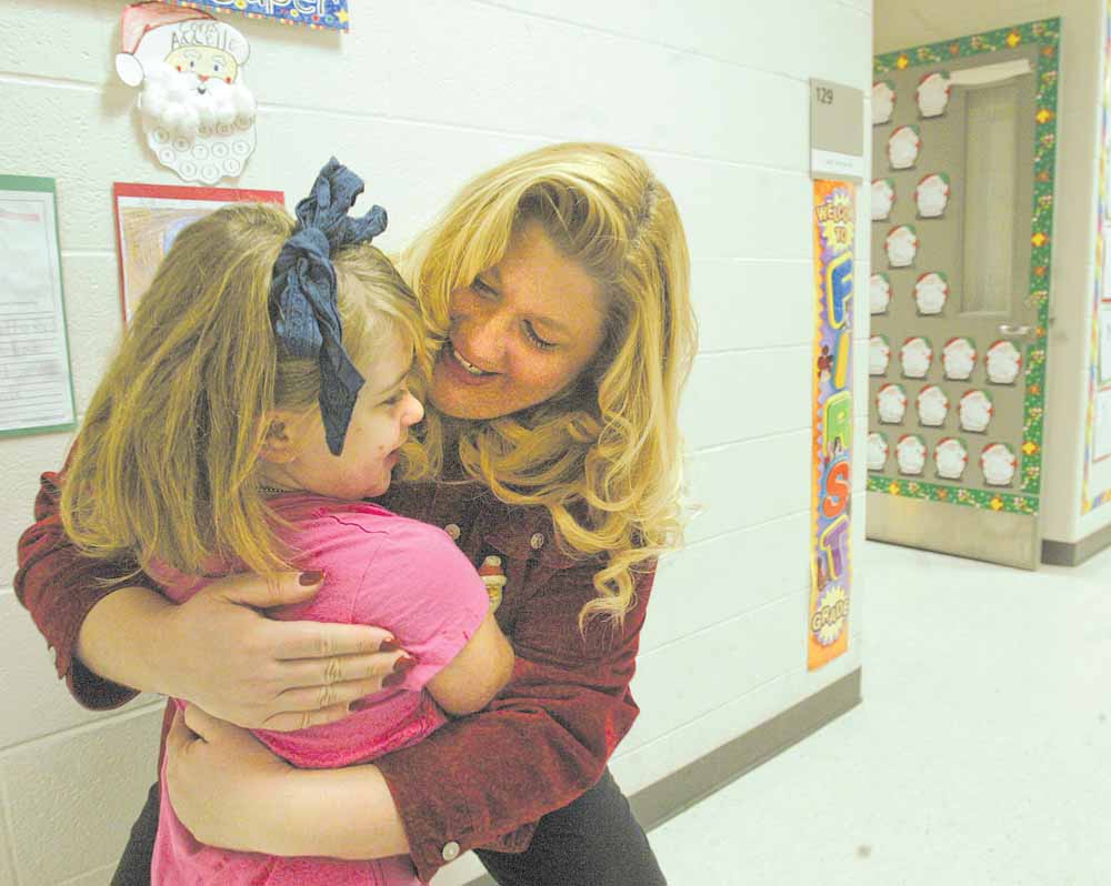 Struthers Elementary School Principal Maggie Kowach hugs first-grade Student Lauryn Mileto. The principal has formulated a list of strategies to encourage students to attend school regularly during Count Week - The period of time when students in a district are counted to determine funding for the district.