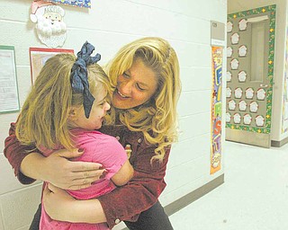 Struthers Elementary School Principal Maggie Kowach hugs first-grade Student Lauryn Mileto. The principal has formulated a list of strategies to encourage students to attend school regularly during Count Week - The period of time when students in a district are counted to determine funding for the district.