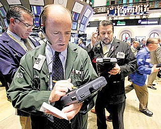 In this Dec. 2, 2010 file photo, Andrew O'Connor, second left, works with fellow traders on the floor of the New York Stock Exchange. 