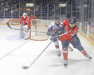 Conner Kucera of the Des Moines Buccaneers fights for possession of the puck against Phantom Ty Loney.