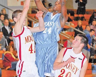 Youngstown East's #24 Antonio Woods puts up a shot while Cardinal Mooney's #42 Doug Caputo and #20 Joe DeNiro get in front of him.