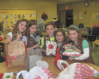 Holiday wrap session: Girl Scout Brownie Troop 157 of Holy Family School in Poland members have “adopted” children who live at the Beatitude House in Youngstown. In October the troop provided the youngsters with goodies, and in December they contributed small gifts and stuffed stockings for each of the children. Displaying some of the gifts they wrapped are, from left, Annie Daprile, Ava Szalay, Lucy Graziano, Anna Wollet and Lucia Naples.