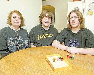Travis Court, 15, right, qualified to go to a national Academic Games Leagues of America tournament this year. Pictured with him are his mother, Betsy Court, and his brother Josh, 20, at their Ellwood City, Pa., home.