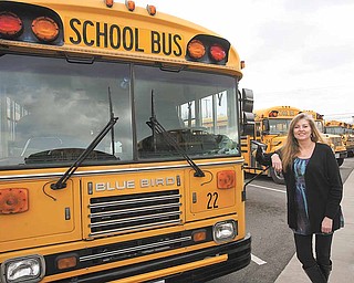 Transportation Director Colleen Murphy stands next to one of 50 Austintown school buses. The district received a grant from the Ohio EPA to retrofit 31 vehicles in its fleet.